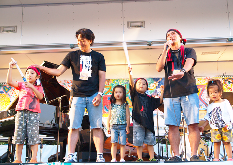 子どもたちと舞台に立つ山田直大さん（左）と能厚準さん（右）