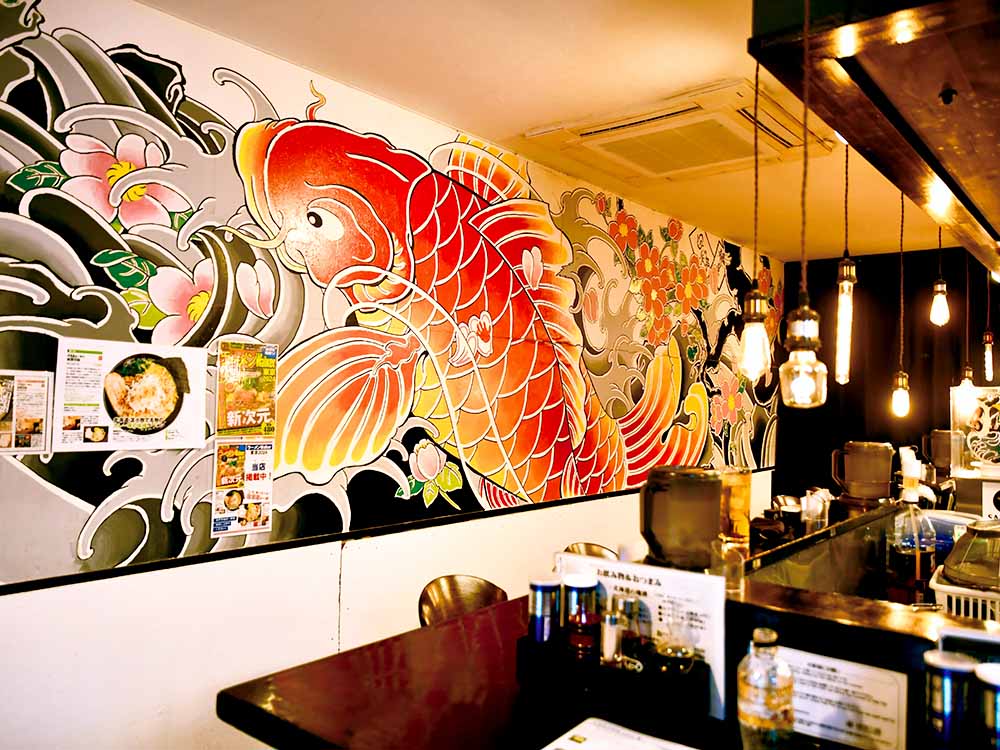 カウンター席の後ろの壁一面には「登り鯉」。たまたま自宅の近所に住んでいた彫り師さんの作品。